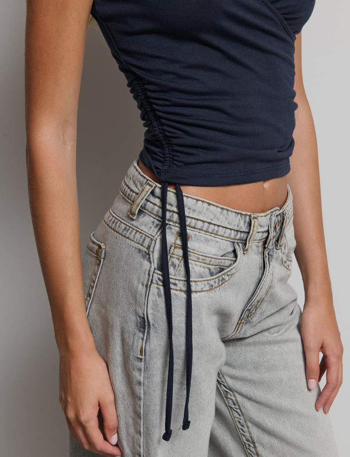 Top manica corta con scollo incrociato e arricciatura sui fianchi.