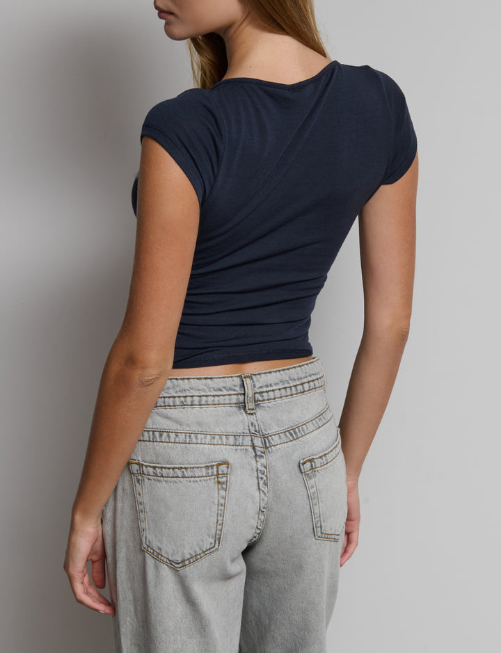 Top manica corta con scollo incrociato e arricciatura sui fianchi.