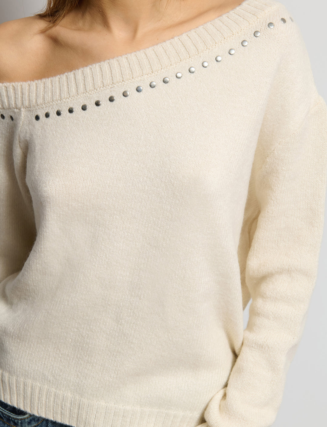 Maglione off-shoulder con borchie