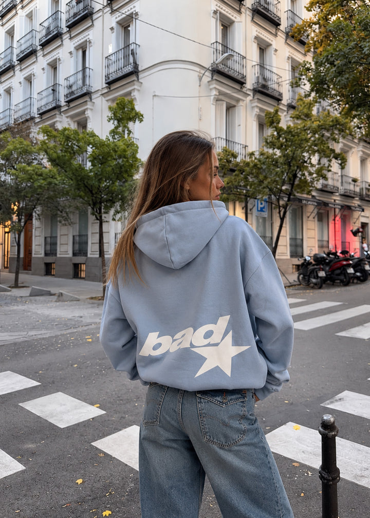 Felpa azzurra oversize con cappuccio e stampa "bad" copertina