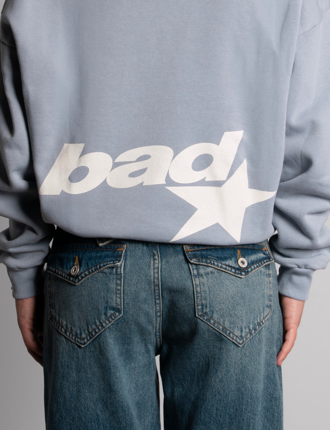Felpa azzurra oversize con cappuccio e stampa “bad” dettaglio