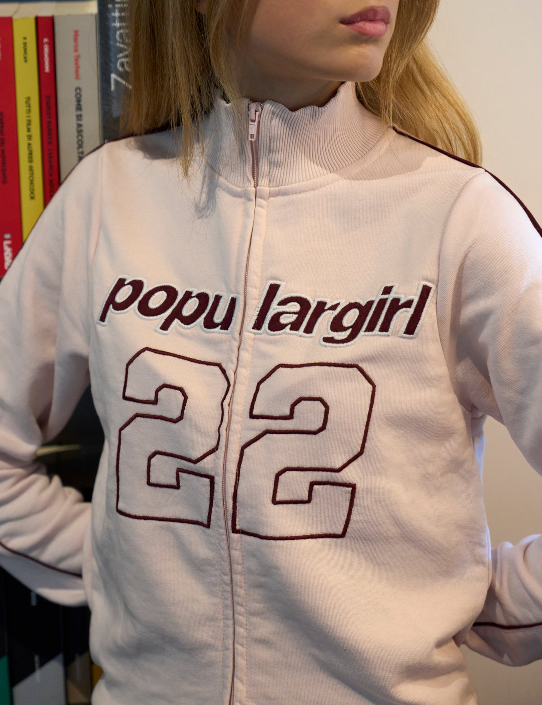 Felpa rosa con collo alto e ricamo “popular girl” con numero 22 copertina