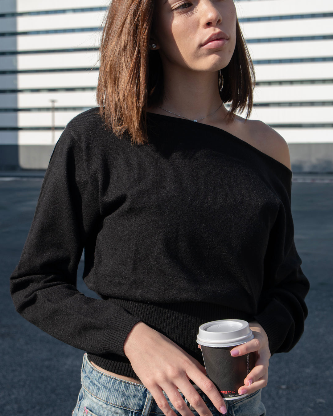 Maglione nero a maniche lunghe con scollo asimmetrico copertina