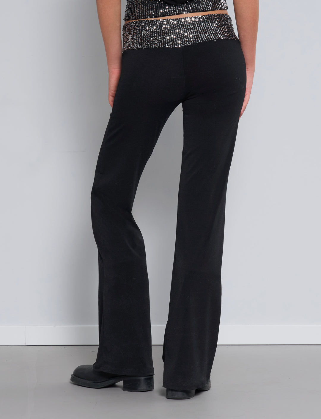 Pantalone con gamba svasata e fascia di paillettes in vita retro