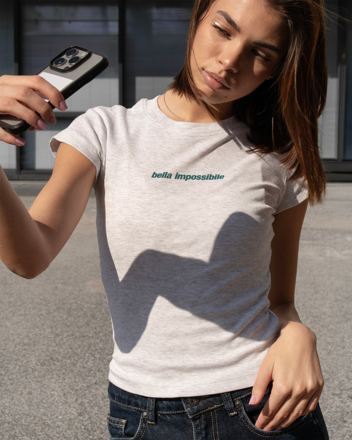 T-shirt grigia con scritta "bella impossibile" copertina