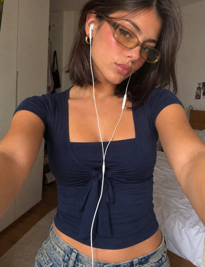 Top blu navy a maniche corte con fiocco frontale copertina
